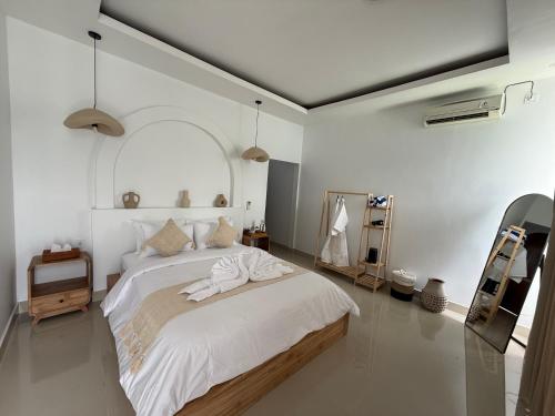 a bedroom with a large bed with white sheets at Uma Danu Villas Kintamani in Kubupenlokan
