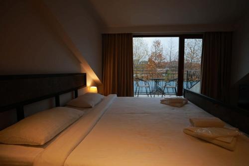 a bedroom with a large bed and a balcony at Hotel Nicolo in Tbilisi City