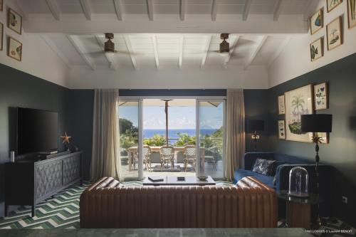 a living room with a couch and a large window at Villa 1493 in Gustavia