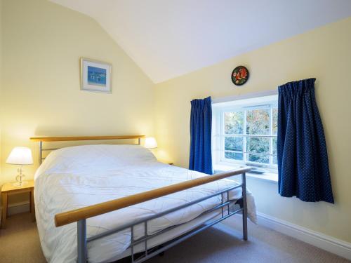 a bedroom with a bed and a window at Carpenter's Cottage in Matlock