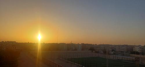 Sunny sky في القصير: غروب الشمس فوق مدينة بها ملعب تنس