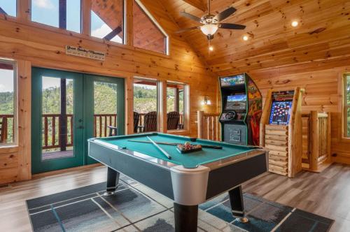 a game room with a pool table and a video game at Hibearnator in Sevierville