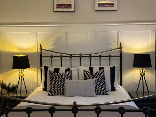 a bedroom with a bed with pillows and two lamps at Antfield House in Inverness