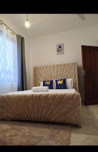 a bedroom with a large bed with blue pillows at Vescon 1 in Mombasa