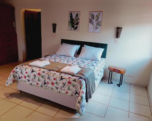 a bedroom with a large bed with a bedspread and pillows at Refúgio dos Pássaros in Gonçalves