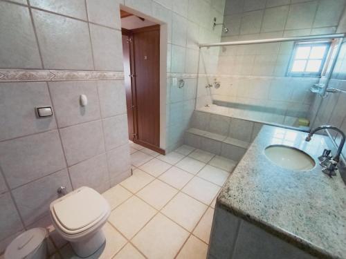 a bathroom with a toilet and a sink and a shower at Refúgio dos Pássaros in Gonçalves