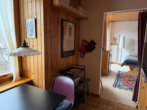 a dining room with a table and a bedroom at Gemütliches Studio im Zentrum in Evolène
