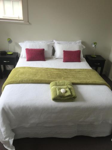 a bed with two pillows and a towel on it at Davidsons Luxury Homestay in Lower Hutt