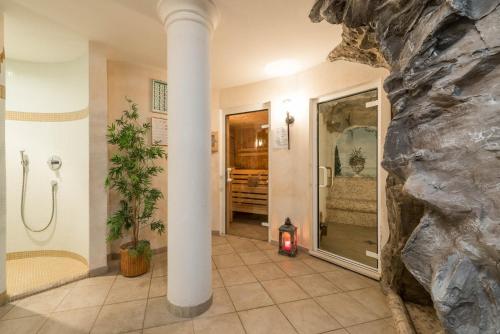 a bathroom with a large stone wall and a pillar at Hotel Kaserhof in Valles