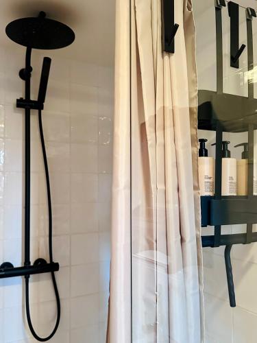a shower in a bathroom with a shower curtain at B&B de Perenboom in Eck en Wiel