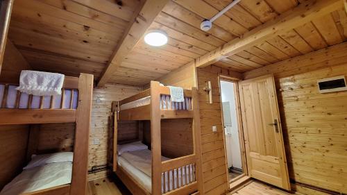 a wooden cabin with two bunk beds in it at Casa lu` Cojocar in Stulpicani