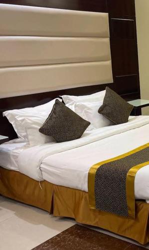 a bed with two pillows on top of it at كيان الين- ابها in Abha