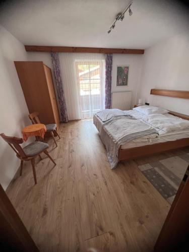 a bedroom with a bed and a chair in it at Ferienwohnung Steiner in Scheffau in Scheffau am Wilden Kaiser