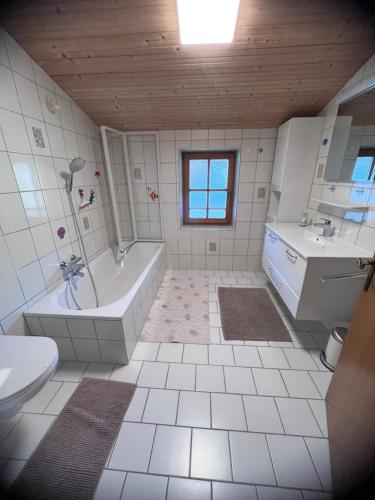 a bathroom with a tub and a sink at Ferienwohnung Steiner in Scheffau in Scheffau am Wilden Kaiser