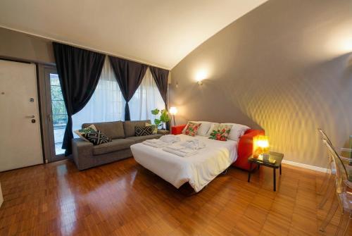 a bedroom with a large bed and a couch at Navigli Experience in Milan