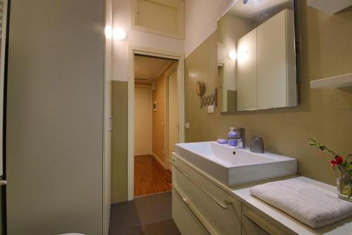 a bathroom with a white sink and a mirror at Navigli Experience in Milan
