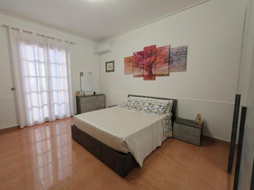 a bedroom with a bed and a painting on the wall at A casa di Picci in Avola