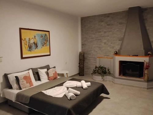 a bedroom with a large bed and a fireplace at ANGO First Floor Apartment in Stavros