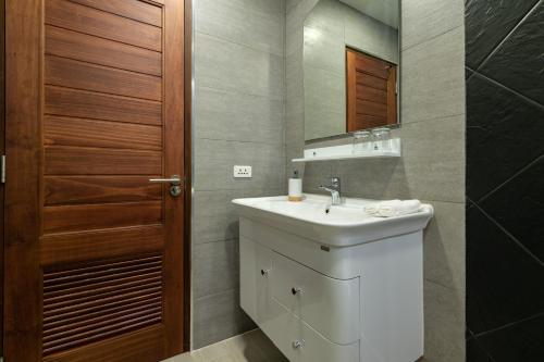 a bathroom with a sink and a mirror at Maneeya Park Residence in Bangkok
