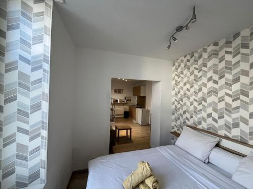ein Schlafzimmer mit einem Bett und einer Wand mit geometrischen Mustern in der Unterkunft Le Cocon - studio Centre ville tout équipé in Bourges