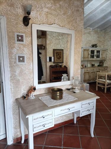 a white dressing table with a mirror in a room at Funtana e Caddos apartment in Berchidda
