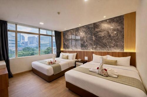 a hotel room with two beds and a large window at Swiss Hotel Kuala Lumpur in Kuala Lumpur