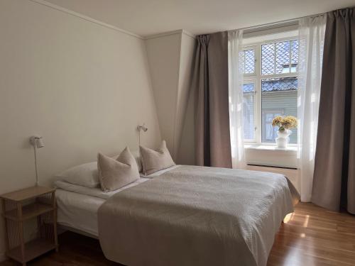 ein weißes Schlafzimmer mit einem Bett und einem Fenster in der Unterkunft Blue House Odda in Odda