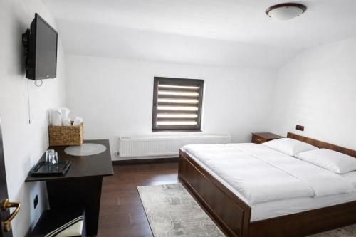 a bedroom with a bed and a desk and a television at Casa de vacanta Naty in Colibiţa