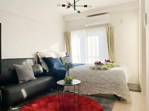a living room with a bed and a couch at BEST LOCATED SHINJUKU CENTRAL Full-Furnished APARTMENT 3minWalk to Station2 in Tokyo