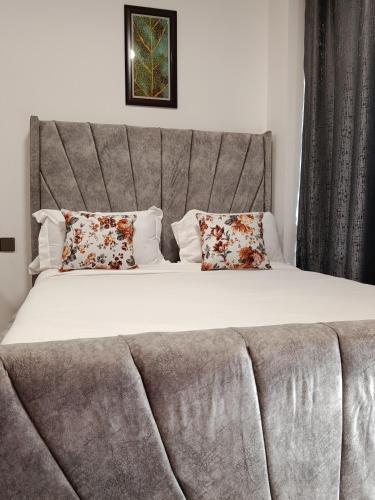 a large bed with a couch in a bedroom at Little Haven Stays-Near UN & Two Rivers in Ruaka