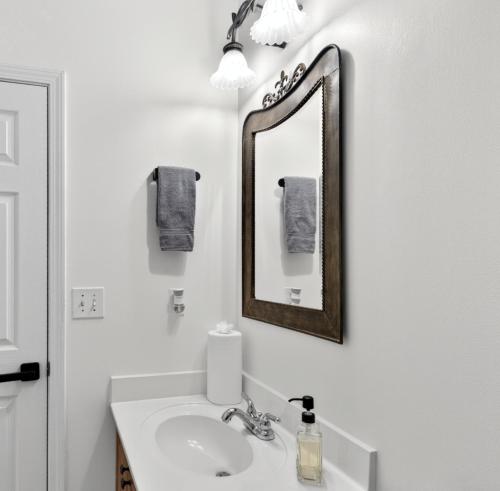 a white bathroom with a sink and a mirror at The Executive Suite in McDonough