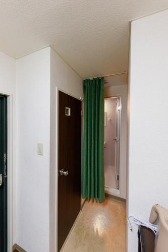 an empty room with a green curtain and a door at なな宿 浅草三ノ輪 in Tokyo