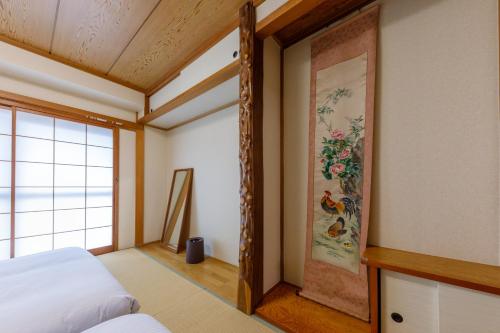 a bedroom with a bed and a painting on the wall at なな宿 浅草三ノ輪 in Tokyo