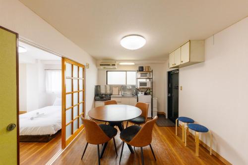 a room with a table and chairs and a bed at なな宿 浅草三ノ輪 in Tokyo