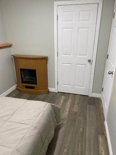 a bedroom with a bed and a door and a tv at Oakhill Oasis guest house in Moores Mills