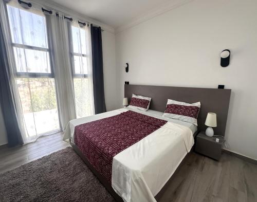 Un dormitorio con una cama grande con una ventana grande. en Villa Solaya, en Bamako