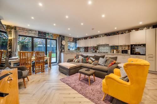 a living room with a couch and a kitchen at Winterbourne House in Fleet