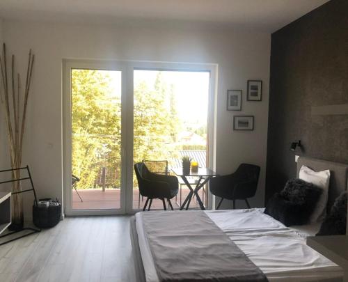 a bedroom with a bed and a table with chairs at LigetResidence Apartman in Fonyód