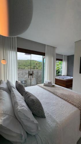 a bedroom with a large bed with a large window at Cipó Lofts - 3 lofts incríveis na Serra do Cipó in Santana do Riacho