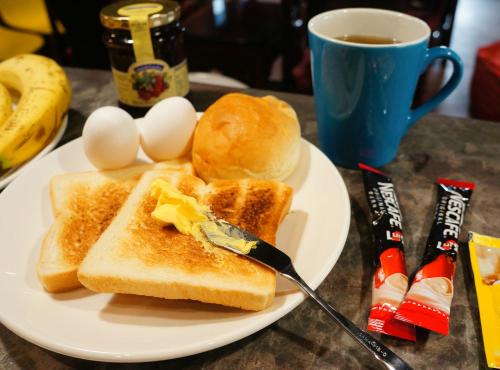 a plate with eggs and toast and a cup of coffee at Taipei Discover Hostel in Taipei