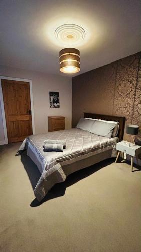 a bedroom with a large bed and a chandelier at BALLYHOURA, Kildorrery, Beautiful 5 bed quite convenient location in Kildorrery