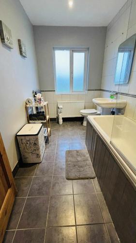 a bathroom with a tub and a toilet and a sink at BALLYHOURA, Kildorrery, Beautiful 5 bed quite convenient location in Kildorrery