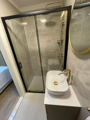 een badkamer met een douche en een witte wastafel bij Rooms Marija in Split