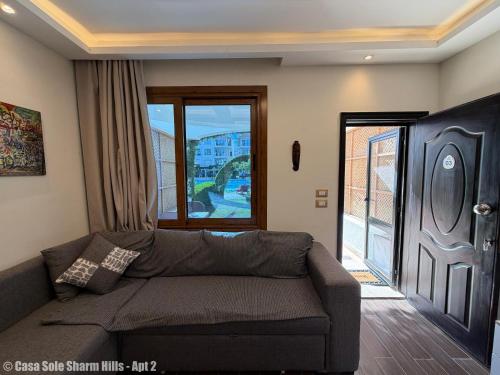 a living room with a couch and a large window at Casa Sole Sharm Hills Apt 2 in Sharm El Sheikh