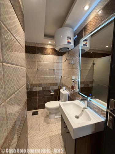 a bathroom with a sink and a toilet and a mirror at Casa Sole Sharm Hills Apt 2 in Sharm El Sheikh