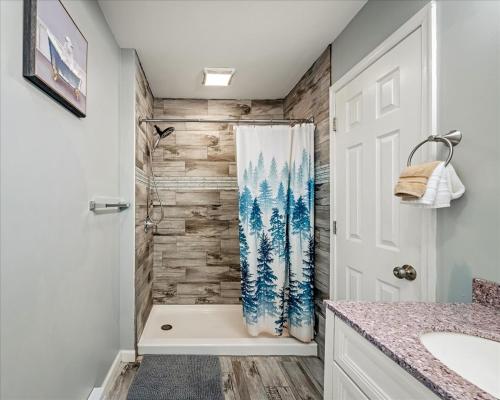 a bathroom with a shower with a wooden wall at Pocono nirvana in East Stroudsburg