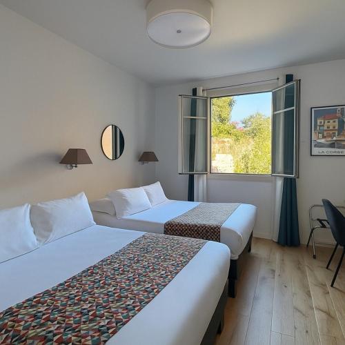 a hotel room with two beds and a window at Hôtel Posta Vecchia in Bastia