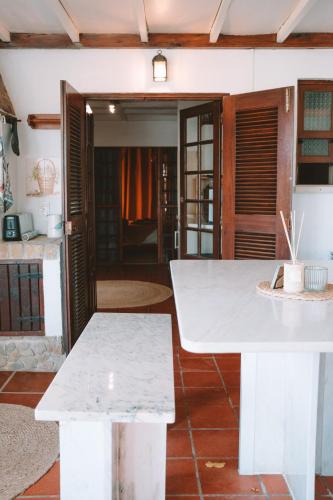 a white table and benches in a room at João Jungle in Açafora