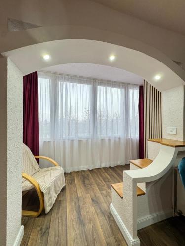 a living room with a desk and a window at Riverside Apartment in Lugoj