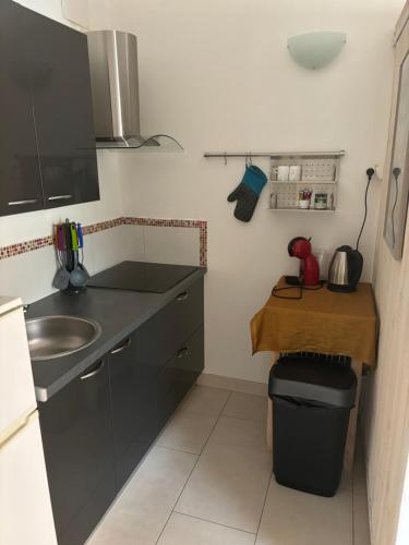 a small kitchen with a sink and a table at Golfe de Saint Tropez Terrasses de Sylvabelle Gigaro in La Croix-Valmer
